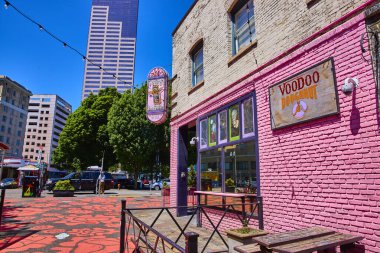 Çarpıcı pembe cephesi ve tuhaf vudu bebek logosu ile modern gökdelenlerin zeminine kurulmuş ikonik Voodoo Donut dükkanının olduğu canlı Portland sahnesi. Şehir ve aşçılık için mükemmel.