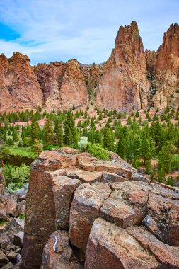 Oregon 'daki Smith Rock State Park' ta engebeli tepeler ve canlı yeşillikler. Maceraya hazır olun ya da bu jeolojik harikanın dingin güzelliğinin tadını çıkarın. Yolculuk ve doğa temalı için mükemmel.