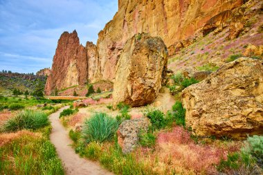 Oregon 'daki Smith Rock State Parkı' nın güzelliğini keşfedin. Huzurlu bir patika, yüksek kaya oluşumlarına doğru esiyor. Yürüyüşçüler ve doğa aşıkları için mükemmel. Macera ve sükunet peşindeler.