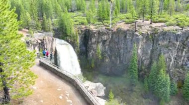 Oregon 'daki Tumalo Şelaleleri havadan izleniyor. Heybetli fotoğraf görkemli şelaleyi, engebeli uçurumları ve gür çam ormanlarını gözler önüne seriyor. İzleme platformundaki turistler bu nefes kesici doğayı güçlendiriyor
