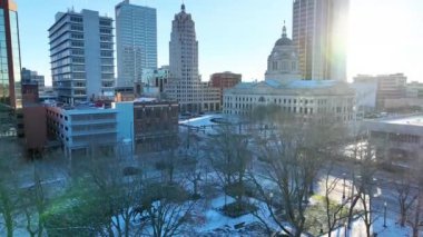 Fort Wayne Indiana şehir merkezinin havadan çekilmiş resmi tarihi Allen County Adliyesi ve Friemann Meydanı 'nı vurguluyor. Karla kaplı çatılar ve çıplak ağaçlar sakin bir kış ortamı yaratır.