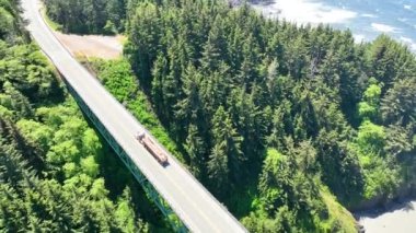 Thomas Creek Köprüsü 'nün gündüz görüntüsü, Oregonlar' ın en yükseği, Samuel H. Boardman Eyalet Sahne Koridoru 'nda arka planda Pasifik Okyanusu ile yoğun bir ormanı geçiyor. Sakin ve...