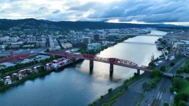 Broadway Köprüsü 'nün ikonik kırmızı kirişi, yansıtıcı Willamette Nehri ve aydınlık şehrin ufuk çizgisinin yer aldığı mavi saat boyunca Portland, Oregon' un şaşırtıcı görüntüsü.