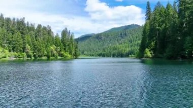 Clearwater Gölü, Oregon 'un dingin güzelliğini tecrübe edin. Bakir sular, yükselen yeşil ağaçlar ve görkemli dağ sıraları sakin, dalgın bir doğal ortam yaratır.