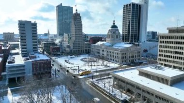 Kış aylarında Fort Wayne Indiana şehir merkezinin kaldırım manzarasında tarihi Allen County Adliyesi ve yakınlarındaki karla kaplı caddeleri ve sakin bir trafik yaratan gökdelenler görülüyor.