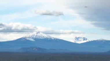 Bend, Oregon 'un havadan çekilmiş çekim görüntüleri Bachelor Dağı' nın görkemli karlı zirvelerini ve Üç Kız Kardeş 'i dingin bir gökyüzüne karşı sergiliyor.