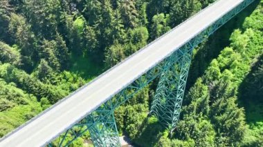 Thomas Creek Köprüsü 'nün büyüleyici manzarası Oregonlar' daki yemyeşil ormanların üzerinde yükseliyor Samuel H. Boardman Eyalet Sahne Koridoru. Oregonlar en uzun köprü mühendislik harikalarıyla Pasifik 'i harmanlıyor.