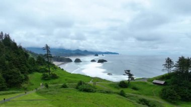 Hava Yayası Çekimi, Amerika Birleşik Devletleri, Oregon, Seaside, Indian Beach: Engebeli kıyı uçurumlarını, geniş kumlu plajları ve yemyeşil bir zemin ve derin sulardaki ikonik deniz yığınlarını deneyin