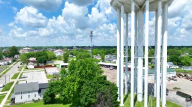 Hava Yayası Çekimi: Huntington Indiana 'nın yükselen manzarası ikonik beyaz su kulesini vurguluyor tarihi adliye binası ve şehirler parlak bir gökyüzü altında yerleşim ve sanayi alanlarının karışımı