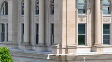 Indiana 'daki Huntington County Adliyesi' nin hava manzarası klasik mimari, Amerikan bayrağı ve toplumsal simgeleri parlak, hoş bir atmosferle vurguluyor. Tarihin temaları için ideal