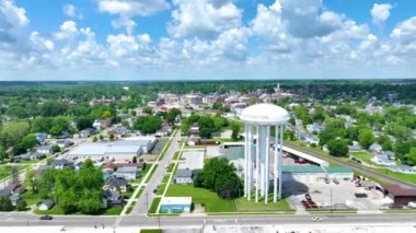 Huntington, Indiana 'nın manzaralı manzarası, ikonik su kulesini ve iyi planlanmış kasaba planını gösteriyor. Parlak gökyüzü ve gür yeşillik cazibeyi ve sükuneti vurgular.
