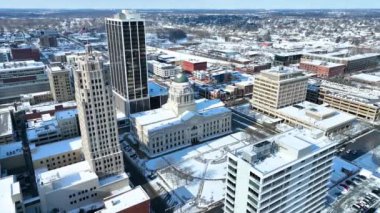 Fort Wayne Indiana 'nın kış mevsiminde havadan çekilmiş görüntüleri. Yeşil kubbesi ile ikonik Allen İlçesi Adliyesi karla kaplı şehir manzarası arasında duruyor, tarihi sembolize ediyor.