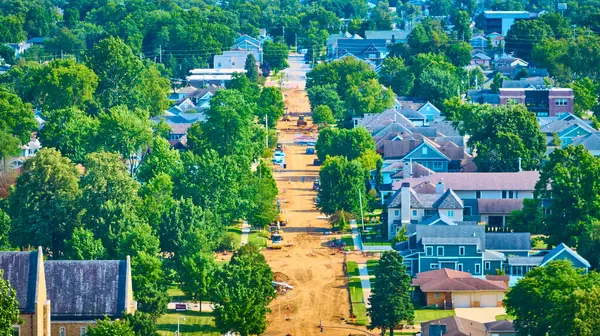 stock image Aerial view of suburban South Bend, Indiana, showing road construction amidst green trees and well-kept homes. Construction vehicles and barriers highlight urban development and infrastructure