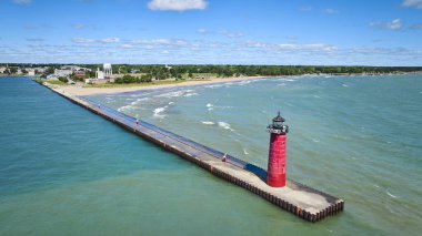 Michigan Gölü 'ndeki Kenosha Deniz Feneri' nin havadan görüntüsü. Parlak kırmızı deniz feneri, teknelere rehberlik ederek iskelede dimdik ayakta duruyor. Sakin sahil şeridi ve küçük kasaba cazibesi güzel bir sahil manzarası yaratıyor.