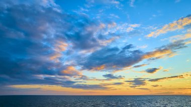 Benton Harbor ve St. Joseph yakınlarındaki Michigan Gölü 'nün sakin hava manzarası. Altın saat gökyüzünü boyar ve sakin denizi sersemletici mavi, turuncu ve sarı tonlarda, yolculuk için mükemmel