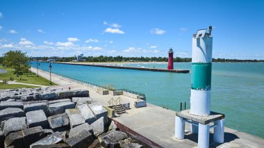 Kenosha, Wisconsin 'deki Michigan Gölü üzerinde güneşli bir günde yeşil çizgili bir fener, manzaralı bir gezinti alanı ve dalgakıran üzerinde kırmızı bir deniz feneri. Seyahat ve turizm temaları için ideal.