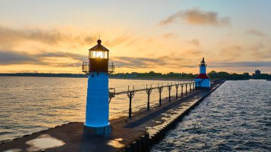 Michigan, Benton Limanı 'ndaki Kuzey İskelesi' nde geçen altın saat Michigan Gölü 'nün sakin sularını yansıtan ve sükuneti sembolize eden iki ikonik deniz fenerinin huzurlu görüntüsünü yakalıyor..