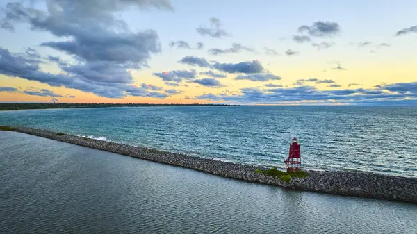 Racine Breakwater Deniz Feneri 'nin Michigan Gölü' ndeki hava manzarası. Canlı gökyüzü, Wisconsin manzaralı kıyı şeridindeki kırmızı deniz fenerini aydınlatan sakin sularla çelişiyor. Tam oldu.