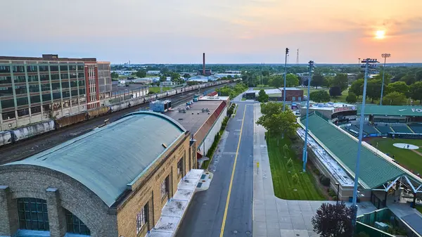 stock image High-angle view of South Bend Indianas Union Station, railway tracks, and Parkwood Field during golden hour. Urban landscape blending industrial heritage with community and recreation. Aerial