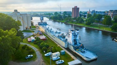 Benton Harbor, Michigan 'daki St. Joseph nehri boyunca demirlemiş bir kargo gemisinin hava görüntüsü. Kalabalık sahnede vinçler, konteynırlar ve kentsel bir arka plana karşı Holcim sanayi tesisi yer alıyor.