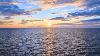 Benton Harbor ve St. Joseph 'in dingin güzelliğini yakalamak için Michigan Gölü' nün altın saatinde çarpıcı bir günbatımının havadan görüntüsü. Sakin sahne dalgalanmadan yansıyan ılık parıltıyı sergiliyor.
