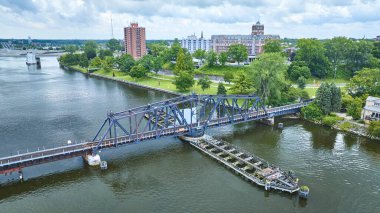 Benton Limanı, Michigan 'ın hava manzarasında St. Joseph Nehri üzerindeki mavi çelik kirişli salıncak köprüsü görülüyor. Bereketli yeşil park ve çeşitli mimari kent arasındaki uyumu vurgular.