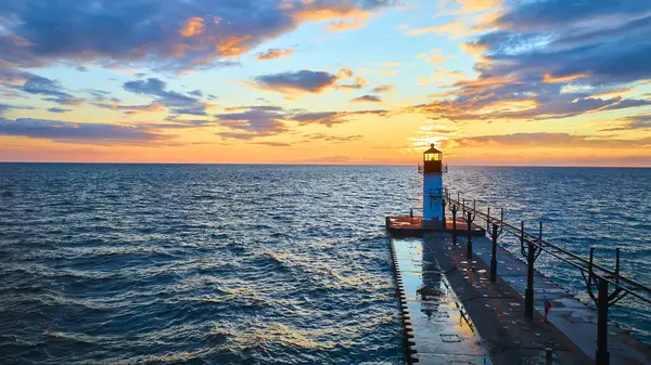 stock image Serene sunset at Benton Harbor pierhead, featuring the iconic St. Joseph lighthouse. The golden hour hues reflect off Lake Michigan gentle waves, capturing tranquility and hope. Ideal for travel and