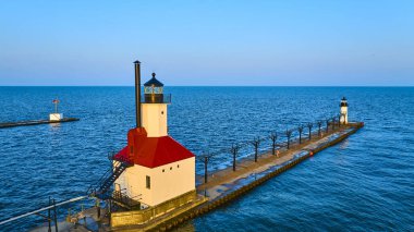 Güneş doğarken St. Joseph Kuzey İskelesi 'nin ikonik kırmızı çatılı deniz feneriyle nefes kesici manzarası. Sakin Michigan Gölü suları sakin bir sahil manzarası yaratır. Yolculuk ve denizcilik için mükemmeldir.