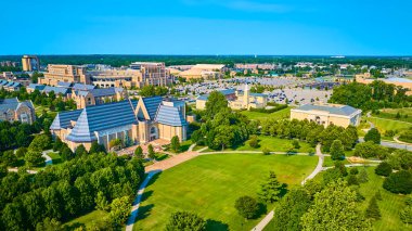 South Bend, Indiana 'daki Notre Dame Üniversitesi' nin hava manzarasında Gotik tarzı binalar, yemyeşil alanlar ve ikonik stadyum, temiz mavi gökyüzü altında gelenek ve toplum geleneklerini ön plana çıkarıyor..
