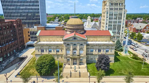 South Bend, Indiana 'daki tarihi St. Joseph Circuit Court' un hava manzarası. Altın kubbesi olan büyük mahkeme binası, modern ve sanat deco gökdelenleriyle çevrili yemyeşil bir alanda duruyor.