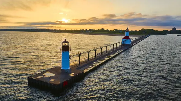 stock image Aerial view of two lighthouses on North Pier in Benton Harbor, Michigan, at golden hour. The serene scene captures the tranquility of Lake Michigan with the warm tones of sunset casting a magical glow