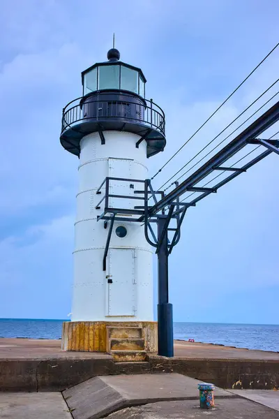 stock image Sturdy white lighthouse stands tall against serene Lake Michigan backdrop, with historic black metal structure beside it. An enduring symbol of maritime safety at Benton Harbors North Pier, St