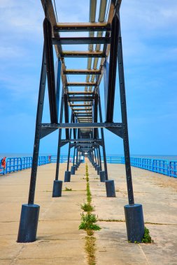 Endüstriyel iskele, Michigan Gölü 'nün sakin mavi sularına doğru uzanır. Geometrik simetri ve doğanın bir dokunuşu, resmetmek için ideal sakin bir kıyı manzarası yaratır.