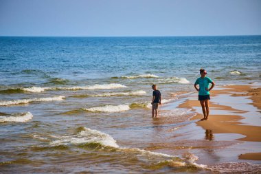 Anne ve oğlu Michigan Gölü 'ndeki Benton Limanı' nda güneşli bir günün tadını çıkarıyorlar. Kadın çocuğu sığ dalgaları keşfederken izliyor, mükemmel bir aile bağı kurma anını yakalıyor..
