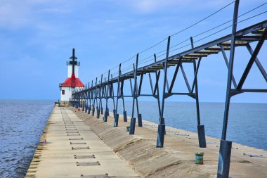 Kuzey İskelesi, Michigan Gölü 'nün sonunda ikonik beyaz kulesi ve kırmızı çatısı olan Benton Limanı deniz feneri. Siyah metal bir yürüyüş yolu bu sakin kıyı sahnesine endüstriyel bir dokunuş ekler..