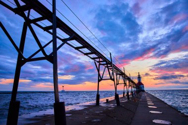 St. Joseph North Pier, Benton Limanı 'nda altın saat Michigan Gölü üzerinde yol gösteren çarpıcı bir deniz feneriyle sakin bir günbatımı. Titrek gökyüzü ve sakin sular huzurlu ve resimsel bir hava yaratır.