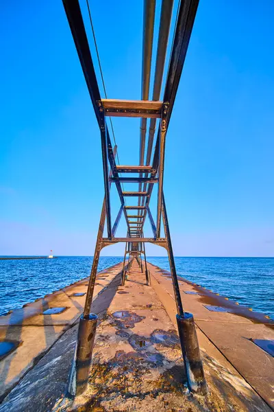 stock image Benton Harbors North Pier extends into Lake Michigan under a clear sky, showcasing industrial elegance with its metal framework. A lighthouse stands in the background, highlighting maritime heritage