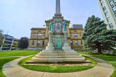 Civil War memorial with bronze soldier statues in an urban park, set against the grand St. Joseph Circuit Court in downtown South Bend, Indiana. A serene blend of history, architecture, and nature. clipart