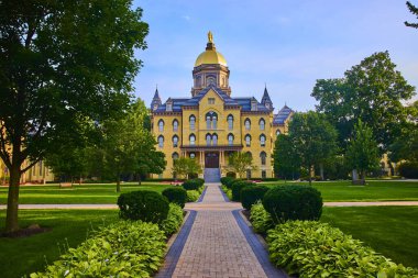 Notre Dame 'ın görkemli altın kubbesi South Bend' deki dingin Tanrı Avlusu 'nun ana binası. Klasik mimari, verimli yeşillik, ve bilimsel atmosfer geleneği ve prestiji çağrıştırıyor. Tam oldu.