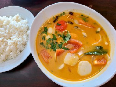 Hindistan cevizi sütü, domates ve kişniş açısından zengin baharatlı altın bir çorba ile Tayland mutfağının tadını çıkarın. Yumuşak beyaz pirinçle eşleştirilmiş. Fort Wayne, Indiana 'da yakalanan bu yemek sıcak ve...