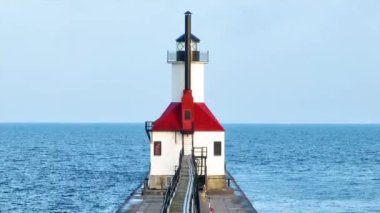 Gün doğumunda Michigan 'daki St. Joseph Deniz Feneri' nin ikonik havadan uçuşu. Deniz feneri Michigan Gölü 'nün sakin sularına ve pastel gökyüzüne karşı duruyor. Kıyıların huzur veren güzelliğini yakalıyor.