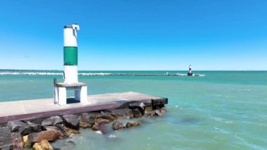 Kenosha Deniz feneri ve Michigan Gölü 'ndeki yeşil navigasyon işaretinin havadan görüntüsü. Sersemletici turkuaz sular ve berrak mavi gökyüzü huzurlu ve sakin bir atmosfer yaratır.