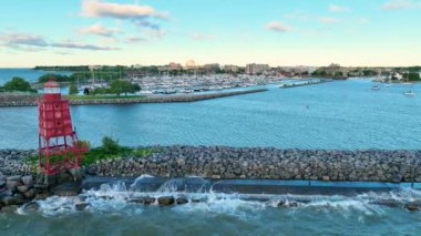 Güneşin doğuşunda Wisconsin 'deki Racine Breakwater Deniz Feneri' nin Hava İzleme Çekimi. Kırmızı deniz feneri Michigan Gölü 'nün sakin sularına Racines marinası ve şehir manzarasıyla karşı karşıya.