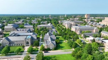 South Bend, Indiana 'daki Notre Dame Üniversitesi' nin ikonik Altın Kubbe, Kutsal Yürek Bazilikası ve yemyeşil alanlar sergilenmektedir. Açık mavi gökyüzü Kampustu