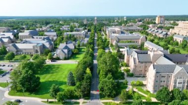 Aerial Fly Over: South Bend, Indiana 'daki Notre Dame' ın nefes kesici üniversitesini ele geçiren bu video, ikonik Altın Kubbe, tarihi binalar ve açık gökyüzünün altında yemyeşil alanlar gösteriyor..