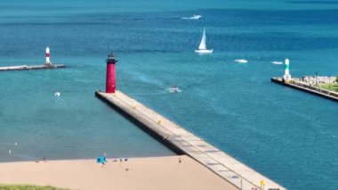 Hava Sabit Çekimi: Michigans Gölü kıyısındaki Kenosha Deniz fenerinin büyüleyici manzarası. Sahile gidenler, tekneler ve yelkenlilerle aydınlık bir yaz günü. Wisconsin 'in sahil güzelliğini sergilemek için mükemmel.