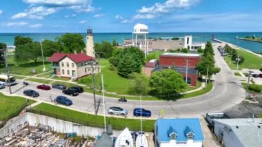 Kenosha Deniz Feneri, Kenosha Gölü 'nün canlı kıyı şeridi ile kırmızı çatılı bir binanın yanında durmakta ve Kenosha Gölü' nün deniz manzarası sergilenmektedir.
