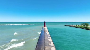 Wisconsin Michigans Gölü kıyısındaki şaşırtıcı Kenosha Deniz Feneri, canlı mavi gökyüzü ve yeşil alanlar tarafından çerçevelenmiştir. Huzuru ve cazibeyi yansıtan resim gibi bir sahne.