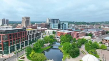 Aerial Fly Over: Kalamazoo, Michigan şehir merkezinde modern ofis binaları, tarihi yapılar ve yeşil alanlar sergileniyor. Çağdaş ve geleneksel mimarinin uyumunu tecrübe edin.