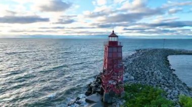 Ark Shot: Racine Breakwater Deniz Feneri 'nin Michigan Gölü' ndeki hava manzarası. Kırmızı deniz feneri durgun sulara karşı dirençli, sıcak sabah ışığında yıkanmış, dengeyi simgeleyen ve